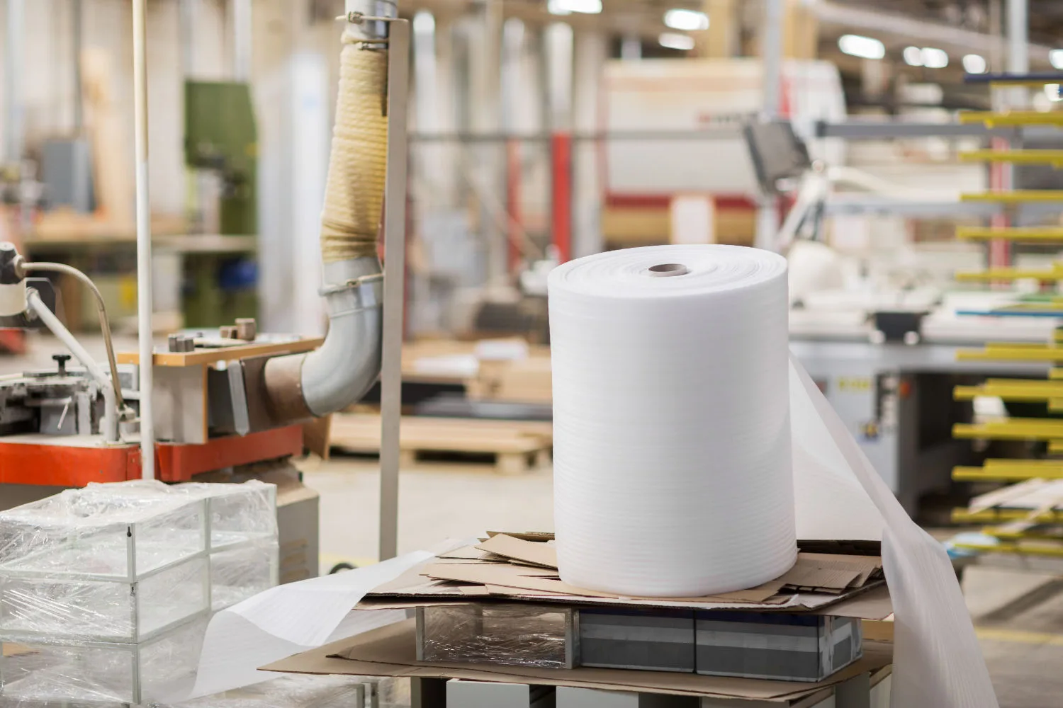 production, manufacture and industry concept - roll of foam wrap at furniture factory workshop globex